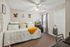 Inviting bedroom with cozy daybed, elegant wall art, and natural light streaming through a large window, complemented by stylish decor and soft carpeting.