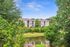 Scenic apartment complex nestled amidst lush greenery with serene pond view, offering a tranquil living environment.