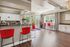 Chic and inviting open-concept kitchen and dining area with modern red bar stools, elegant cabinetry, and abundant natural light.