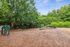 Inviting outdoor dog park with agility equipment surrounded by lush greenery and blue skies.