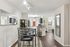 Modern open-concept apartment with elegant dining area, sleek kitchen, and cozy bedroom corner, highlighted by stylish mirrors and ambient lighting.
