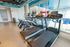 Modern fitness center with state-of-the-art treadmills and exercise equipment, featuring bright interiors and expansive windows.