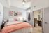 Inviting bedroom with cozy decor, featuring a plush bed, artistic wall frames, and modern ensuite bathroom.