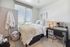 Bright and cozy bedroom with modern decor, featuring a plush bed, stylish desk, and large window offering natural light.