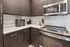 Modern kitchen with sleek dark cabinetry, stainless steel appliances, and elegant countertop space.
