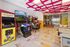 Vibrant arcade room with retro Pac-Man, Golden Tee, and Jurassic Park games, creating a playful and nostalgic atmosphere.