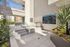 Modern apartment spa area featuring a sleek hot tub, sunlit surroundings, and lush greenery for ultimate relaxation.