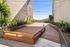 Inviting modern wooden deck surrounded by lush greenery, perfect for outdoor relaxation and entertainment.