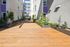 Modern urban courtyard with lush greenery, wooden pathway, and stylish architectural elements.