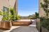 Inviting rooftop terrace with modern planters, lush greenery, and scenic city views, perfect for relaxation and entertainment.
