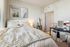 Bright and cozy bedroom featuring soft white bedding, chic decor, and a stylish dressing area.