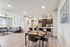 Modern open-concept living and dining area with sleek kitchen, featuring a spacious layout and elegant furnishings in a bright, well-lit apartment.