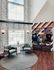 Inviting lounge area with chic furniture, wood accents, and a window showcasing a pool view, exuding modern elegance and warmth.