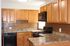 317 south 41st street kitchen with granite countertops, wood cabinets, black appliances; microwave, stove/oven, and dishwasher.