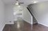 4036 sansom street house living room area with hardwood flooring, view of the kitchen, and staircase to second floor.