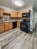 4036 locust street house kitchen with hardwood flooring, granite countertops, wooden cabinets and black appliances; stove/oven, dishwasher, and microwave. philadelphia university city