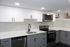 4029 walnut street unit 19 renovated philadelphia university city.  renovated kitchen with white granite countertops, white and grey cabinets, and stainless steel appliances; dishwasher, stove/oven, microwave.