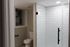 4029 walnut street unit 19 renovated philadelphia university city.  renovated bathroom with white tiled standing shower with black finishes and toilet.