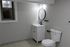 4029 walnut street unit 19 renovated philadelphia university city. bathroom with sink vanity, toilet, and mirror, with black finishes.