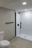 4029 walnut street unit 19 renovated philadelphia university city. renovated bathroom with white tiled standing shower with black finishes and toilet.