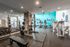 Modern fitness center featuring strength training equipment, mirrored walls, and a cardio zone with exercise bikes and treadmills, enhanced by bright, stylish decor.
