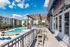Luxurious apartment complex with a stunning pool view, modern outdoor seating, and sunlit palm trees under a bright blue sky.
