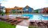 Inviting outdoor pool area with elegant pergola and comfortable loungers, surrounded by charming houses and scenic views.