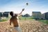 Vibrant outdoor sand volleyball court with players enjoying a sunny day, surrounded by modern residences.