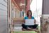 Charming porch with a wooden swing, perfect for relaxation and remote work, featuring a cozy suburban setting.