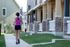 Charming residential neighborhood with a jogger enjoying the well-kept sidewalks and modern townhouse fa&ccedil;ades.
