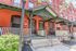 Charming red brick townhouse with inviting front porch and elegant green accents.