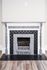 Charming vintage fireplace with intricate detailing, set against a classic wooden floor, creating a cozy ambiance.