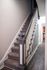 Charming staircase with elegant wooden banister and cozy carpet, leading to an inviting hallway.