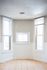 Bright, inviting corner space with large windows and elegant tile flooring, perfect for a cozy reading nook or a sunlit office.