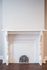 Charming vintage fireplace with intricate white detailing and elegant woodwork, perfect for adding character to any living space.