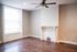 Bright and airy living room with elegant hardwood floors, a stylish ceiling fan, and a charming decorative fireplace.