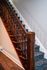 Elegant staircase with rich wooden banister and textured carpet, enhancing the charm of the interior.