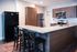Modern kitchen with sleek granite countertops, stainless steel appliances, and elegant wooden cabinets.