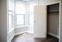 Bright room with large windows and open closet door in a charming home setting.