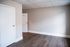 Bright and inviting room with sleek hardwood floors, modern light gray walls, and white doors, ideal for a cozy living space or home office.