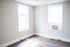 Bright and airy corner room with large windows and sleek wooden flooring, perfect for creating a cozy living space.