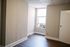 Bright and cozy room with wooden floors and natural light streaming through a window, offering a serene ambiance for comfortable living.
