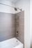 Contemporary bathroom shower with sleek silver faucets and elegant beige tiles.