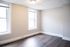 Bright and inviting room featuring two large windows and elegant wood flooring, perfect for a cozy living space.