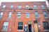 Charming brick apartment building offering modern spaces with large windows, available for Fall 2026 leasing.