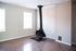 Chic apartment corner featuring a modern fireplace with two bright windows and sleek wood flooring.
