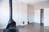 Charming room with sleek wood floors, modern wood-burning stove, and spacious closet, perfect for cozy living.