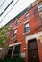 Charming red brick apartment building with elegant architectural details, highlighting classic urban living.