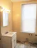 Charming bathroom with elegant marble tiles, warm lighting, and a modern vanity, offering a cozy and inviting ambiance.