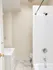 Bright and modern bathroom featuring elegant white tiles, a sleek bathtub, and a stylish vanity cabinet.